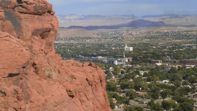 A Panoramic View of St. George, Utah, Showcasing the Cityscape with Red Cliffs in The Foreground and Distant Mountains